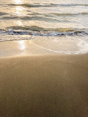 Black Sea waves and sandy beach with water during sunset or sunrise.