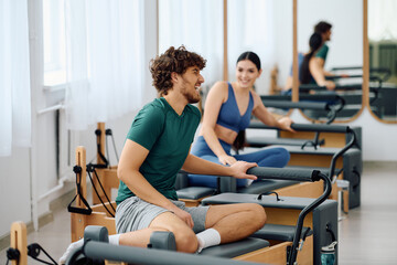 Fototapeta premium Engaging in lively conversation during a dynamic pilates class at a modern studio