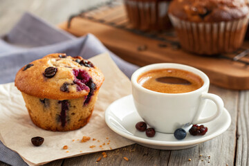 Enjoying a warm muffin and a cup of coffee in a cozy setting on a rustic wooden table