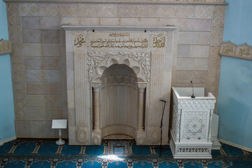 Beautiful spacious hall with a tribune and Arabic hieroglyphs in a mosque close-up