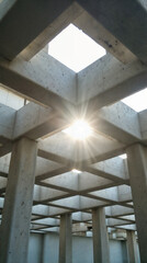 Fototapeta premium A modernist open concrete roof structure casting dramatic light and shadow.