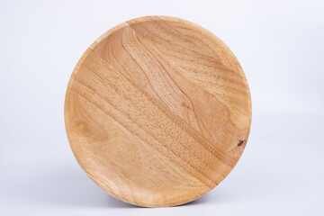 Round plate made of rubber wood on white background