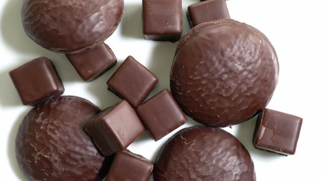 "Dominosteine", and chocolate coated ginger bread, a German and Austrian Christmas specialty, but also known in Switzerland and other countries, rotating on a white plate. 