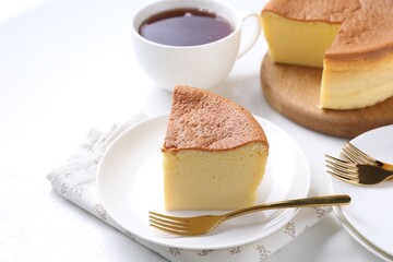 Tasty Japanese Castella sponge cake served with tea on white table, closeup