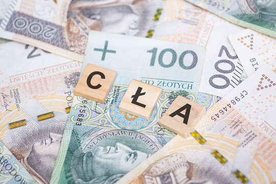 The word Cła ( Tariffs in Polish) on a background of Polish banknotes. A concept illustrating the introduction of tariffs, trade wars, and their impact on the economy