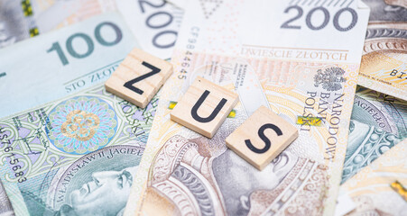 The word "ZUS" (Polish Social Insurance Institution) on a background of Polish banknotes, symbolizing social security, public funds, and financial obligations in Poland