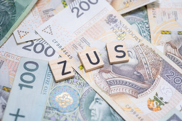 The word "ZUS" (Polish Social Insurance Institution) on a background of Polish banknotes, symbolizing social security, public funds, and financial obligations in Poland