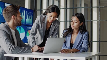 Team collaboration meeting. Two women and one man in business attire analyzing financial reports with interactive data dashboard - Powered by Adobe