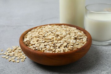 Composition with oatmeal flakes on gray background. Cooking breakfast