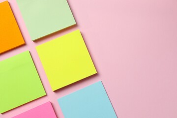 Multicolored paper stickers on a pink background