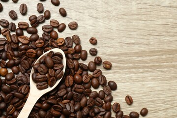 Wooden spoon with coffee beans on wooden background