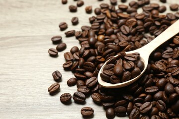 Wooden spoon with coffee beans on wooden background
