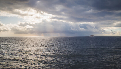 Obraz premium Tranquil Minimalist Seascape Background Created Using Long Exposure Photography, Showcasing Silky Smooth Blue Water and Ethereal Streaked Clouds - Perfect for Zen Concepts and Calming Visuals