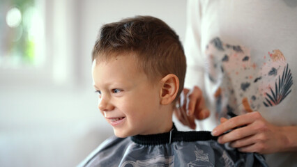Smiling young boy getting ready for haircut at home. Time for a Haircut