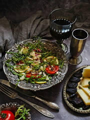 Salad with tomatoes, arugula and red wine on a black background