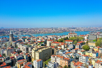 Aerial view of Istanbul and the Bosphorus Strait in Turkey on a sunny day. Aerial perspective showcasing the historic city center with its distinctive red-roofed buildings, the ancient Galata Tower