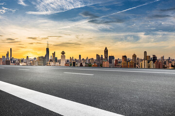 Obraz premium Empty asphalt road and cityscape with modern city skyline at sunrise in Shanghai