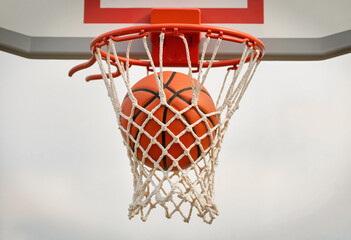 Basketball hoop with ball stuck in net, clear details on rim and net texture