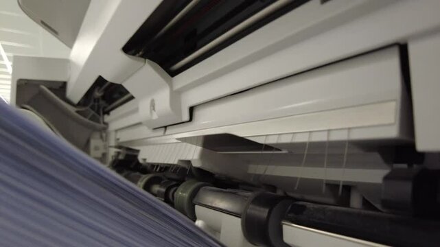 Copier or printing machine runs and prints personalized stapled letters for customers in the office.