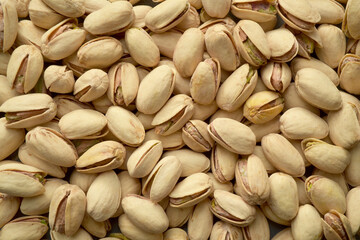 Photograph of roasted and salted pistachio nuts in diffused even light. Top view pistachios. Healthy eating, whole foods. 
