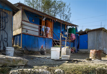 Local liveable shanty made of corrugated iron sheets next to a water pipe