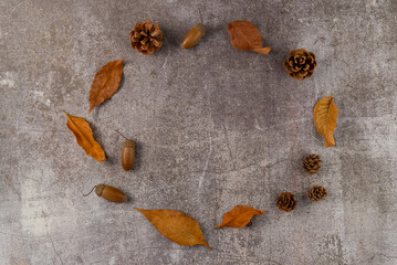 Wreath of leaves, cones,acorns on a gray background. Flat lay, top view. Copy space