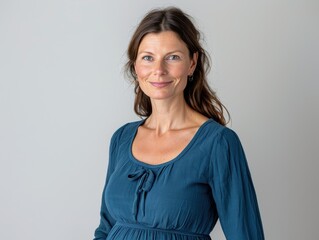 Obraz premium Woman in a blue dress is smiling for the camera
