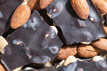 Chocolate pieces with almonds and loose almonds in rustic composition.