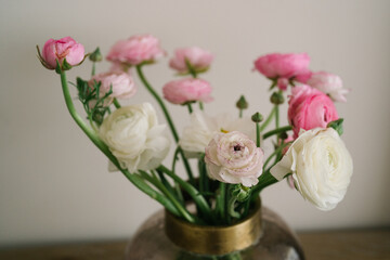 Bouquet of pink and white ranunculus flowers in a glass vase