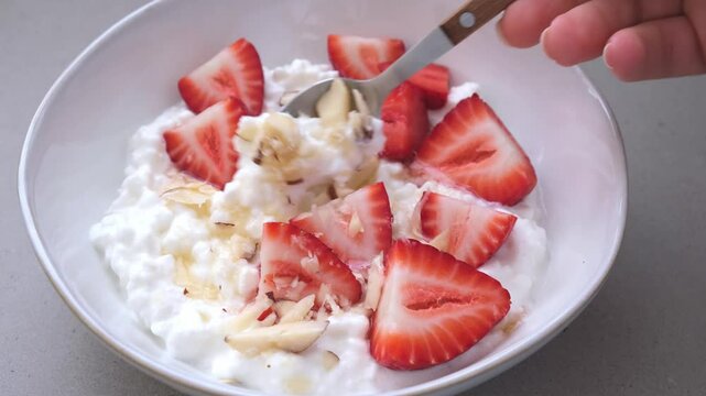Breakfast cottage cheese with honey, strawberry and nuts.