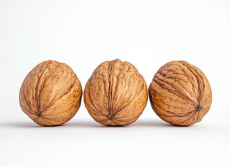 Three Brown Walnuts in a Row on White Background