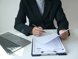 Young businesswoman holds a resume and evaluates it. Views the personal history of job applicants. Recruitment concept