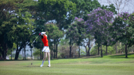 Asian woman professional golfer play golf at golf course with green golf course background, Asian...