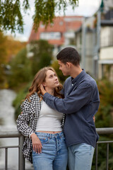 Fototapeta premium Young Cute Female Hugs Boyfriend. In Autumn Outdoor. Lovers Walking in Park. Attractive Funny Couple. Lovestory in Forest. Man and Woman. Cute Lovers in the Park. Family Concept. Happy Couple.