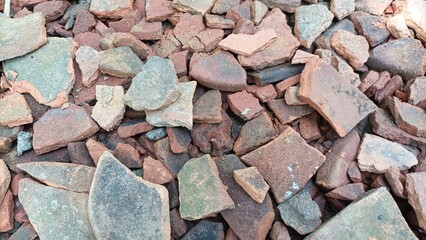 Background of broken roof tiles, shards of red roof tiles left over from the building.