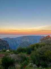 Obraz premium Beautiful sunrise over the mountains and lush greenery at Pico do Arieiro