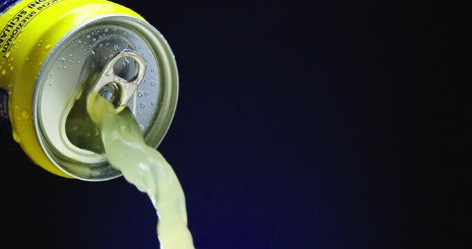 A soda can that is full and overflowing with fizzy liquid and vibrant bubbles inside it