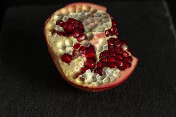 Delicious and fresh pomegranate, a bright fruit on a dark background