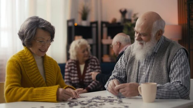 Smiling senior man and woman connecting jigsaw puzzle pieces, stimulating memory