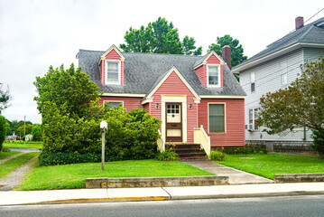 Small cute house. View of the porch with lawn and walkway.