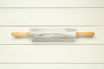 Rolling pin on white wooden table, top view