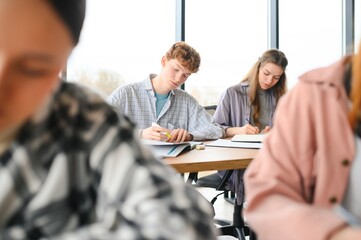 students sitting in a classroom, studying, discussing