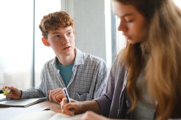students sitting in a classroom, studying, discussing