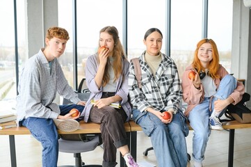 education, food, people and friendship concept, group of happy students eating apples