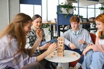 group of young friends playing board games together while sitting around table