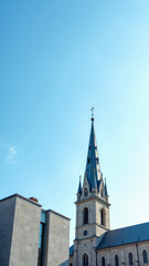 A Christian church with a tall steeple under a clear blue sky.