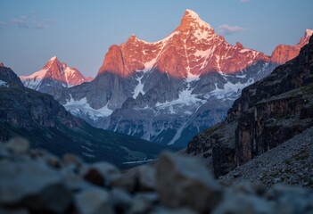 Obraz premium Majestic mountain peaks illuminated by the warm glow of sunset
