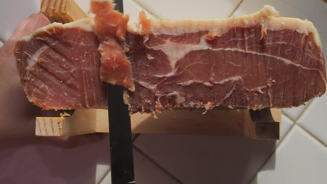 A piece of fresh jamon meat at home in the kitchen in front of the window