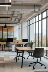 Fototapeta premium Modern office interior featuring desks, computers, and large windows in a bright workspace during the day
