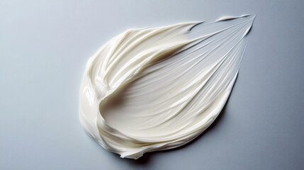 Creamy skincare product swirl on blue background.